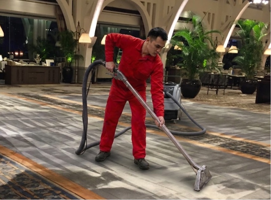 Big Red technician deep-cleaning the carpet of a hotel lobby